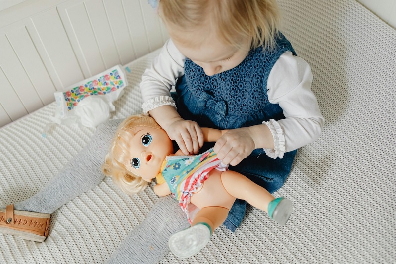 baby playing with a doll