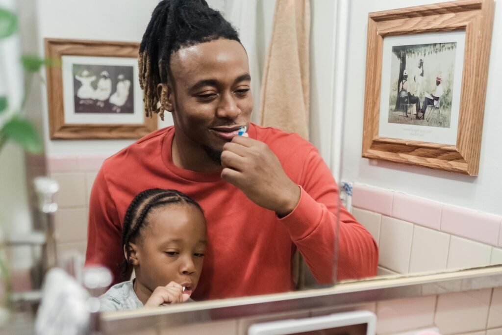 Parent and a child brushing teeth