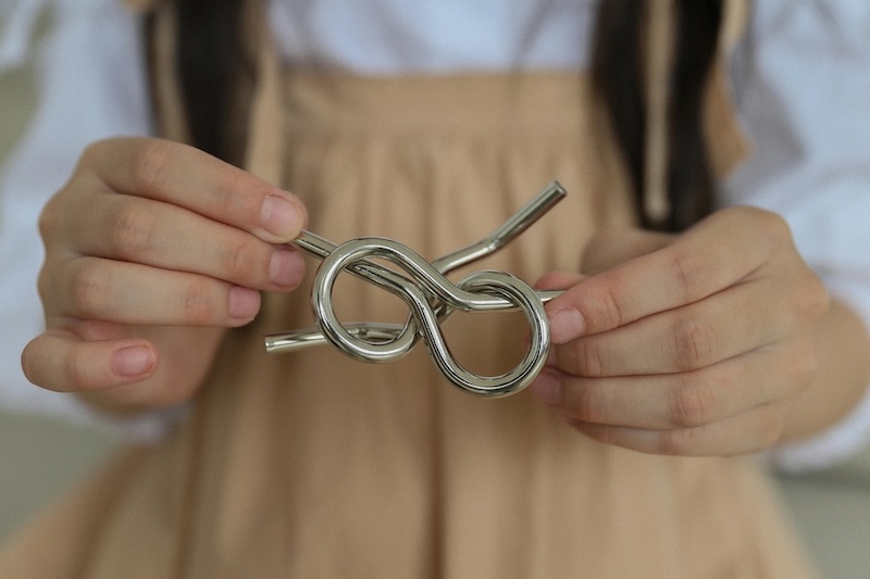 Metal tubes intertwined in someone's hand