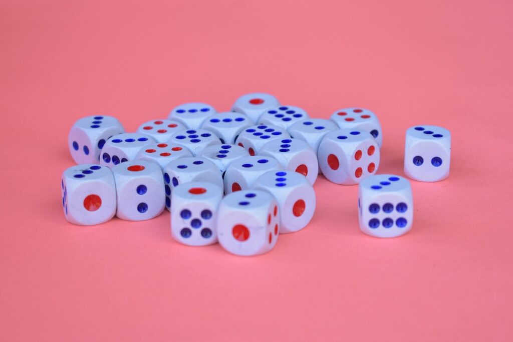 multiple dices placed on a pink background