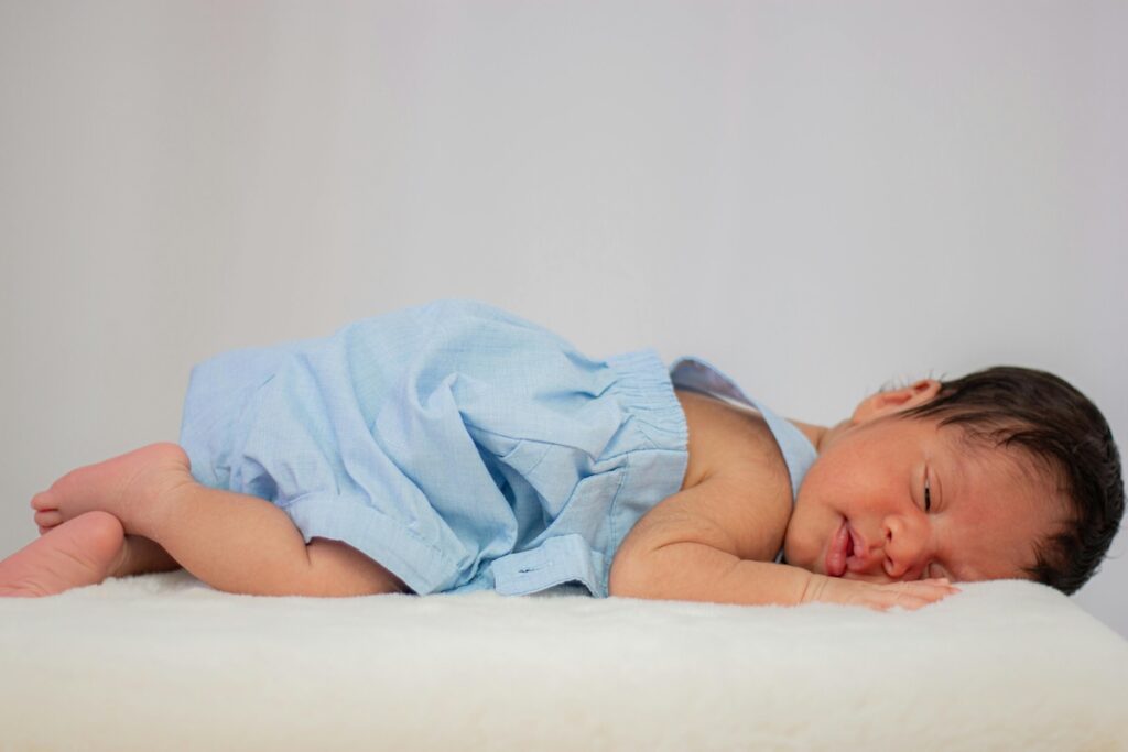 baby laying on the stomach with blue fabric on top