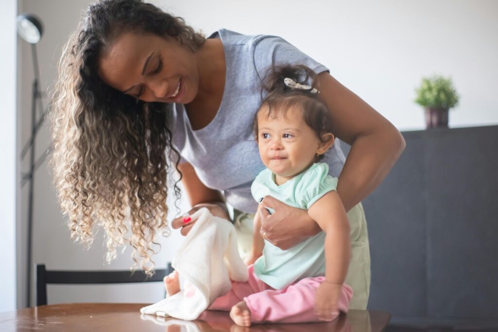 Parent holding a baby and wiping them