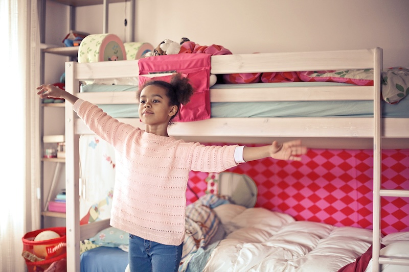 Child standing in front of bunk beds