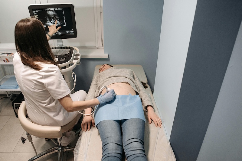 Person lying on doctor's table getting a stomach ultrasound