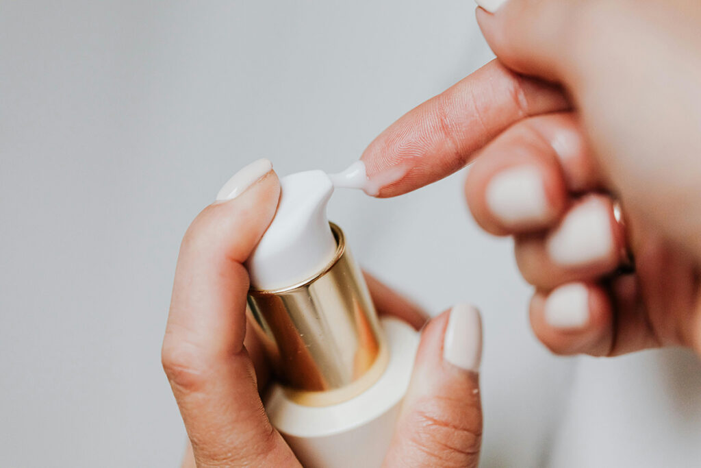 close up of a finger placing moisturizing lotion on it