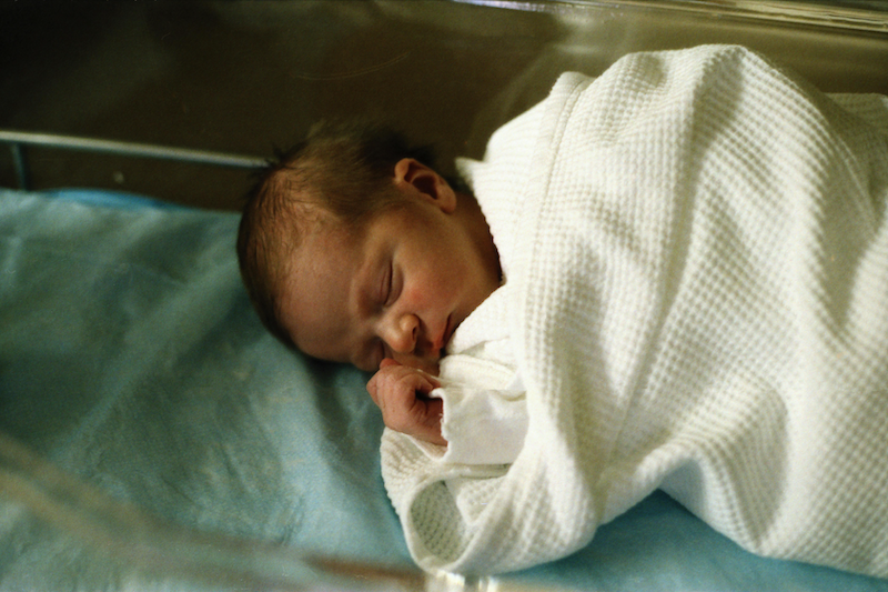 Infant asleep under a blanket