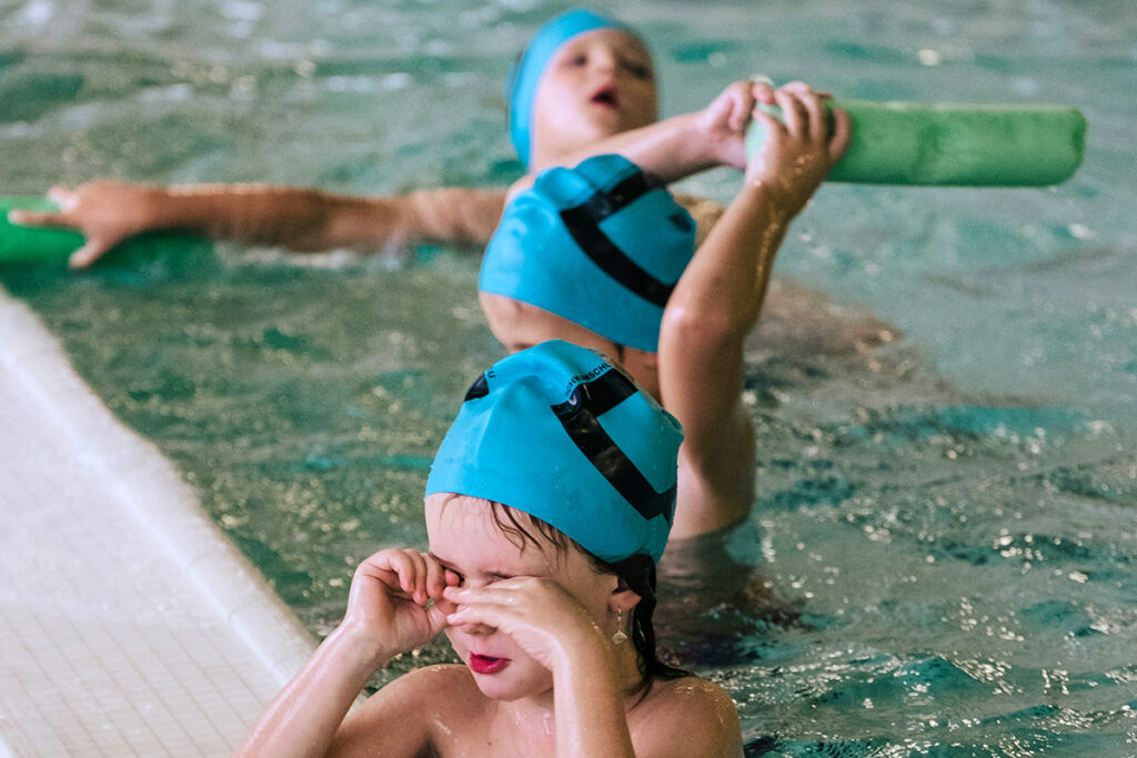 multiple kids swimming in the pool