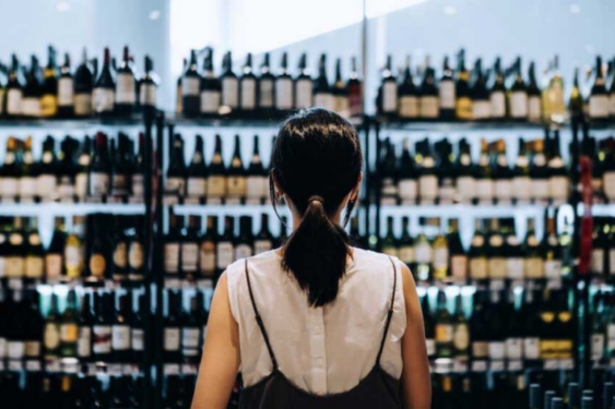 A person looking at alcohol rack.