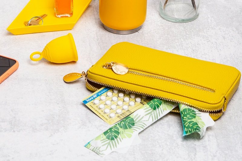 yellow purse on the table containing birth control tablets