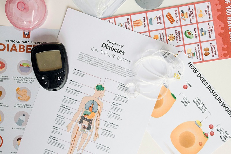 diabetic infographics placed on a table with a glucometer