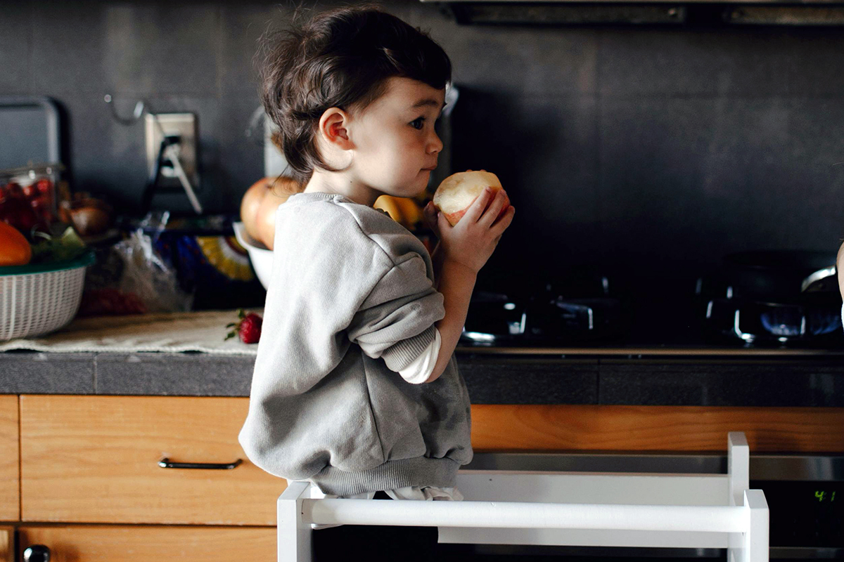 a child standing and eating donut