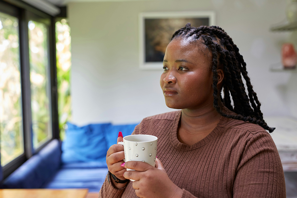 a person holding a cup of tea and sitting in a room