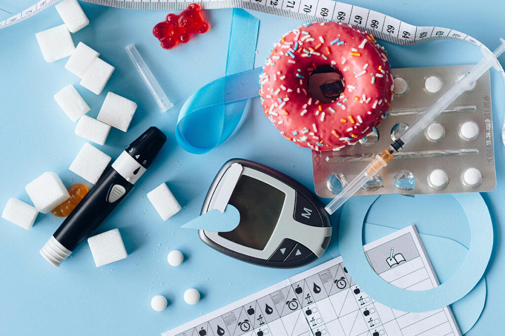 a donut glucometer and some diabetes medicines placed on a table