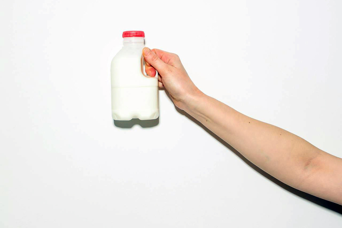 close up of arm holding milk bottle