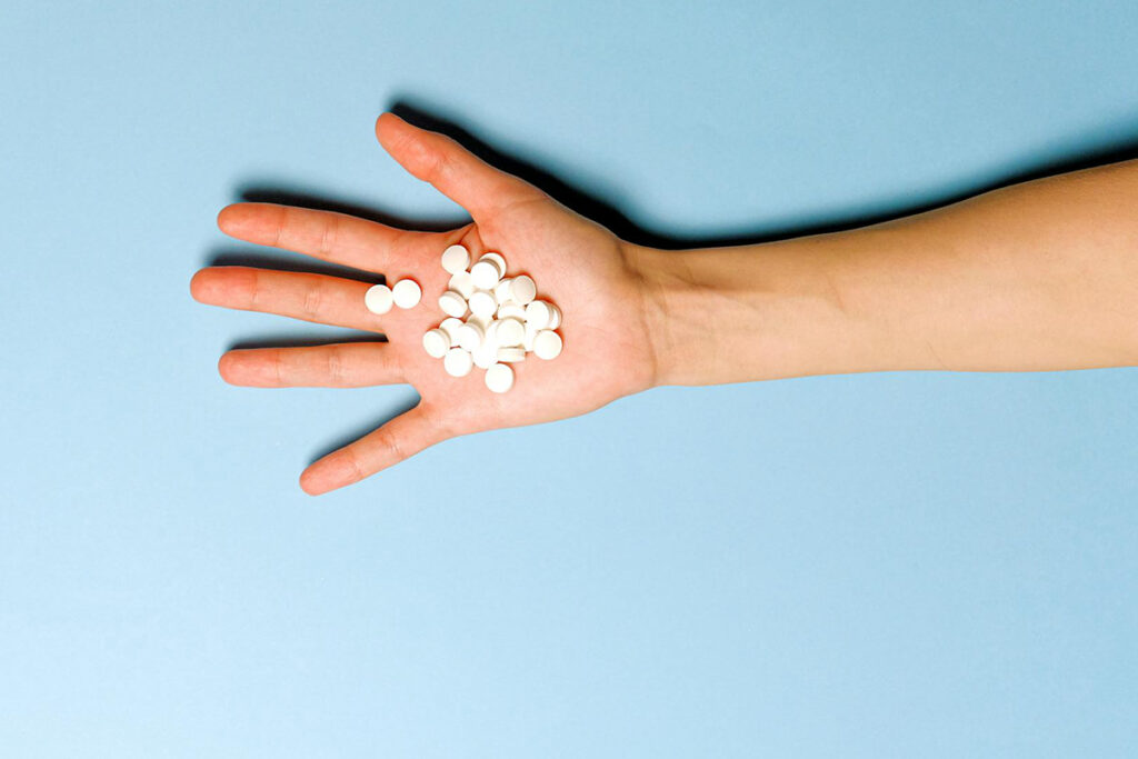 medicines on a hand with light blue background