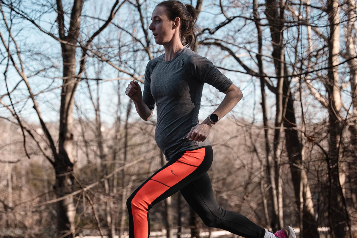 A pregnant lady running in a park