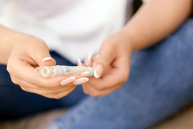 Close up of hands holding an injectable medicine