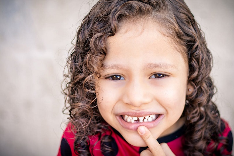 baby smiling and pointing finger on the teeth