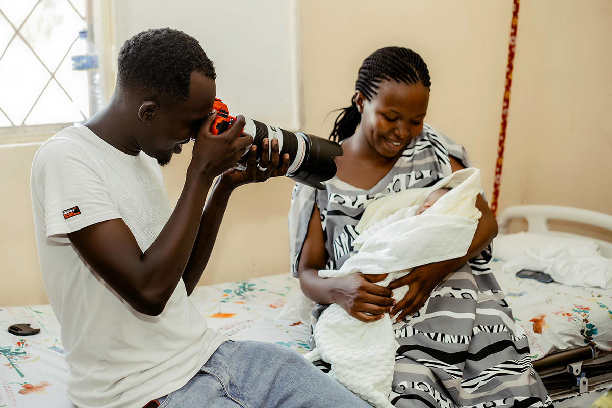 A couple taking pictures of their baby