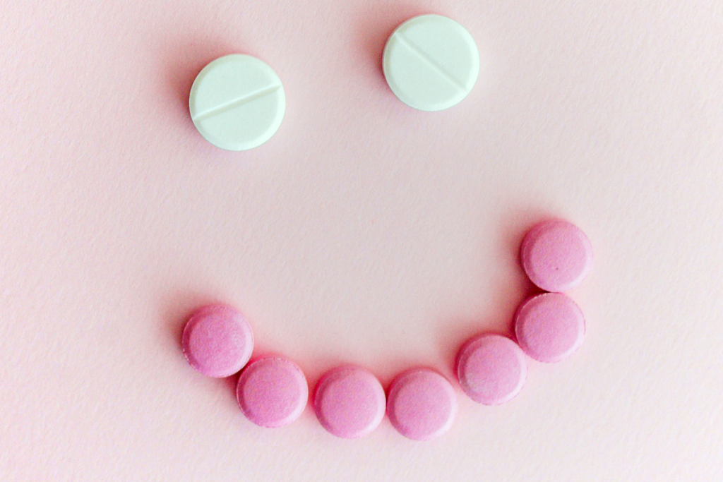 White pills making the eyes and the pink pills making the mouth of a smiley face