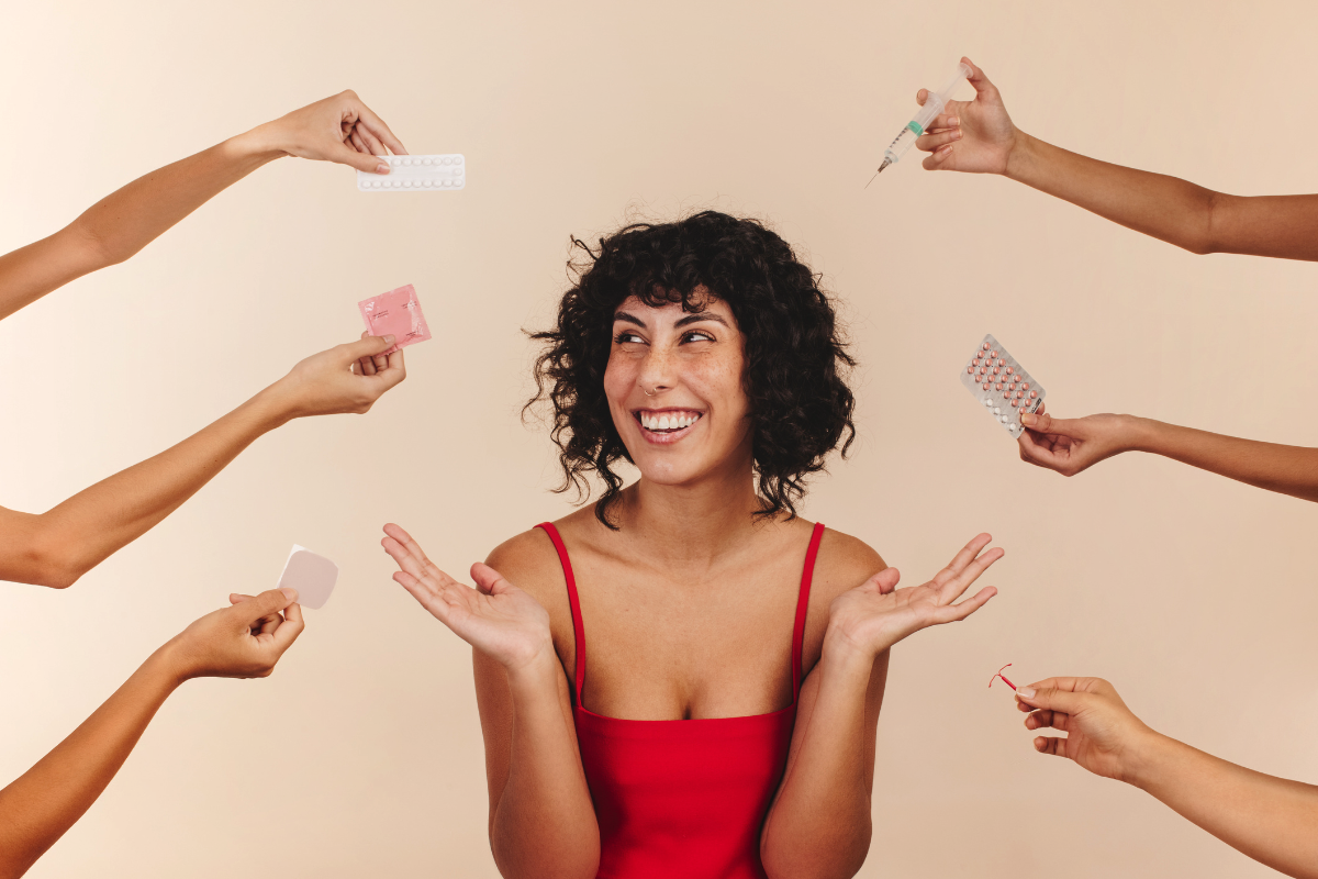 A person sitting and smiling with hands open while 6 hands, 3 from each side hold all means of contraception.