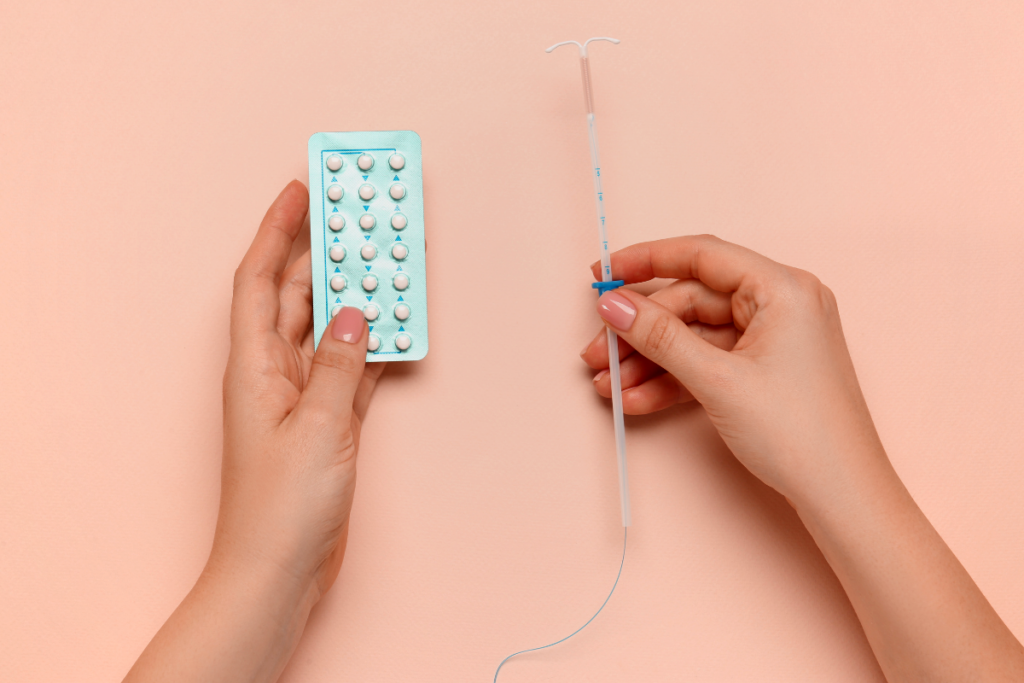 A person holding pills in one hand and syringe in the other