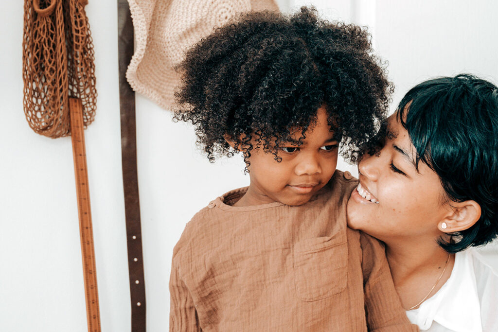 A kid and a parent smiling at each other