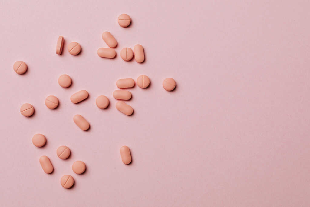 A pink background with peach color pills