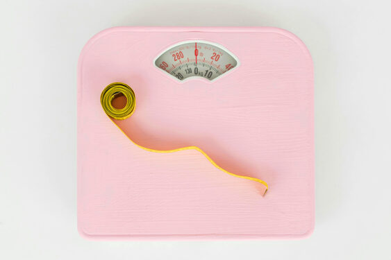 A pink weighing scale and an inch tape