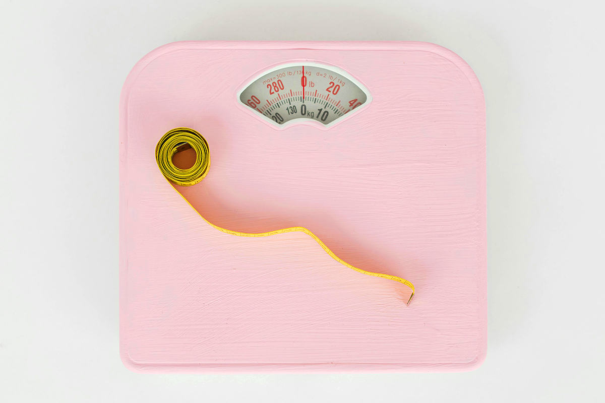 A pink weighing scale and an inch tape