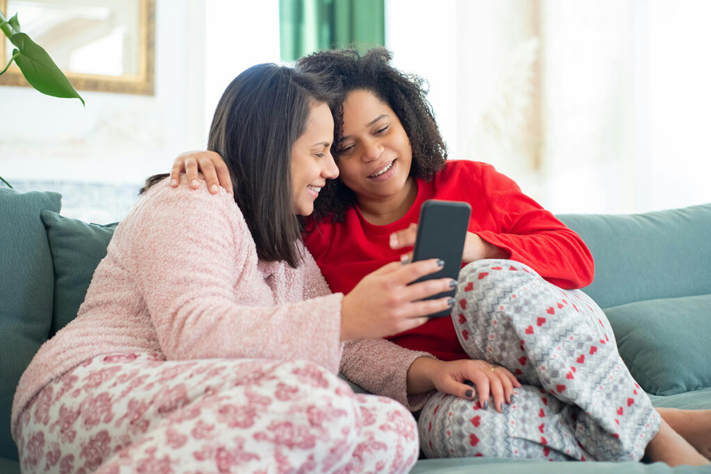 Two people sitting on the couch and looking at the phone