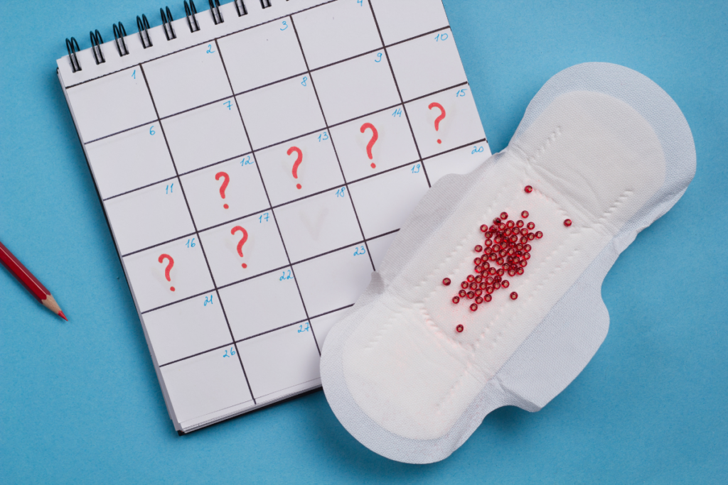 A calender with question marks and a sanitary napkin with red glitters