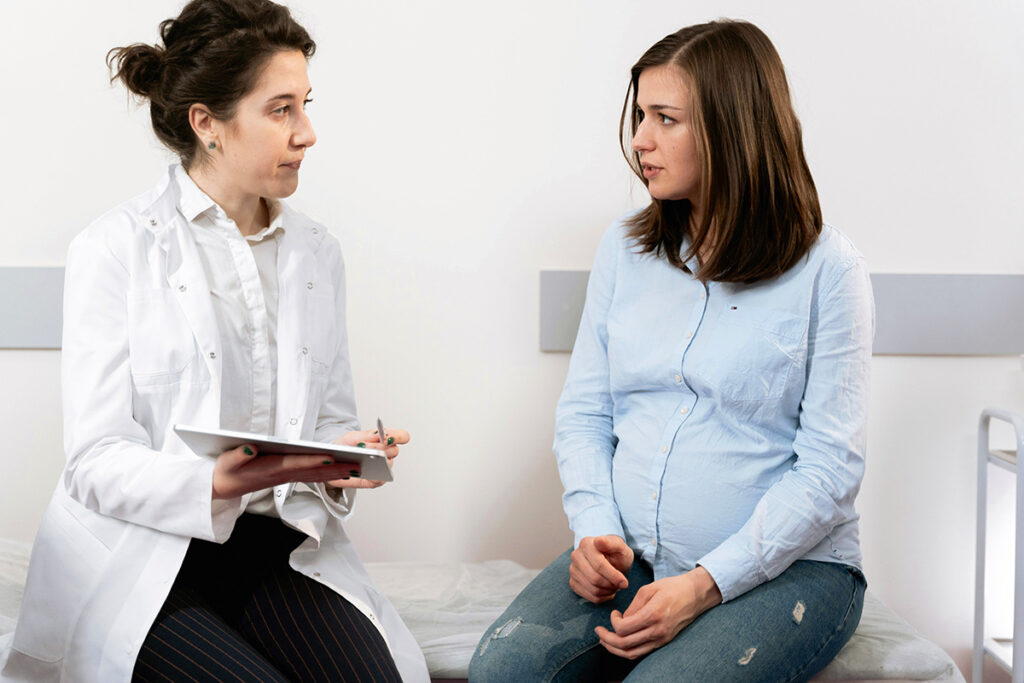 A pregnant person and a doctor discussing