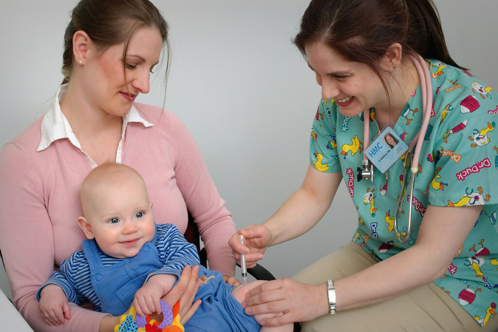 A doctor vaccinating a baby on parent's lap