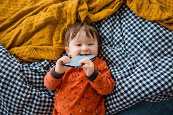 Baby lying down with a phone