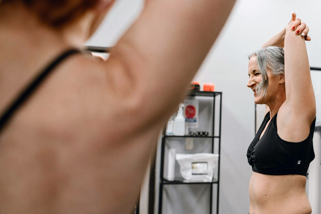 A person stretching her arms in a black sports bra