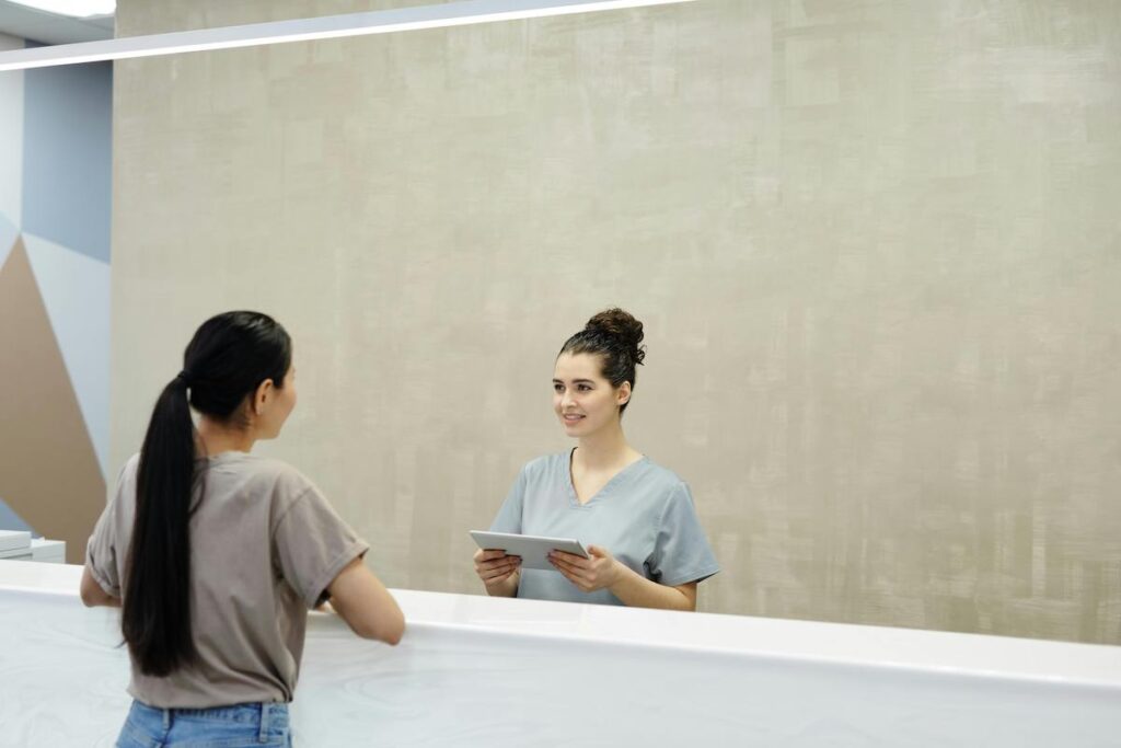 A person talking to a clinic receptionist.