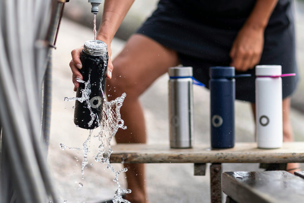 A person filling bottles with water