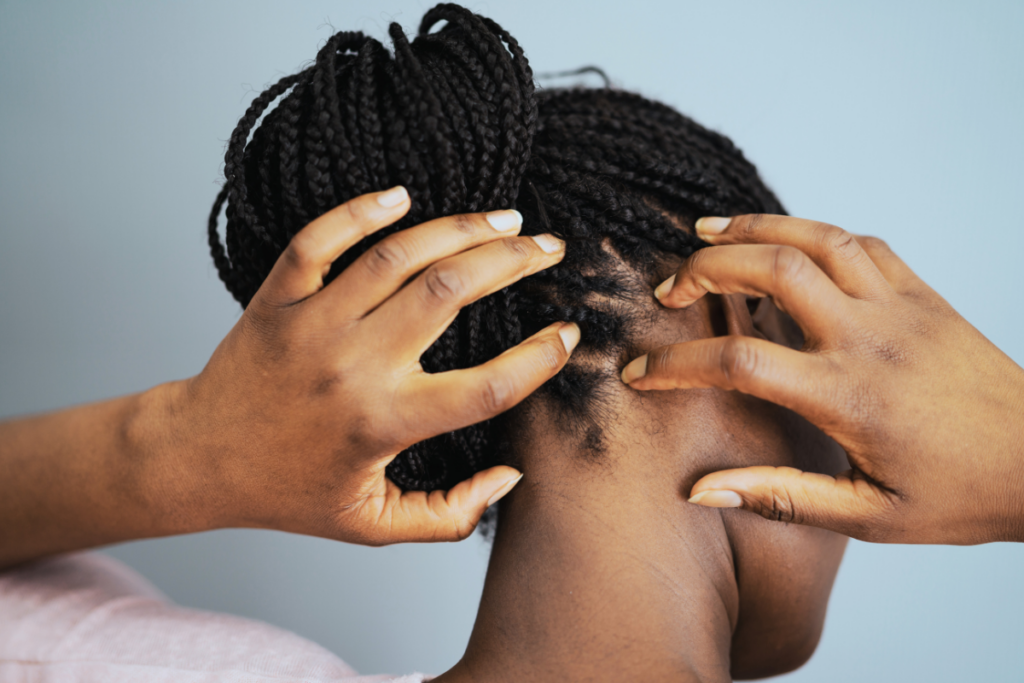 A person scratching her scalp.