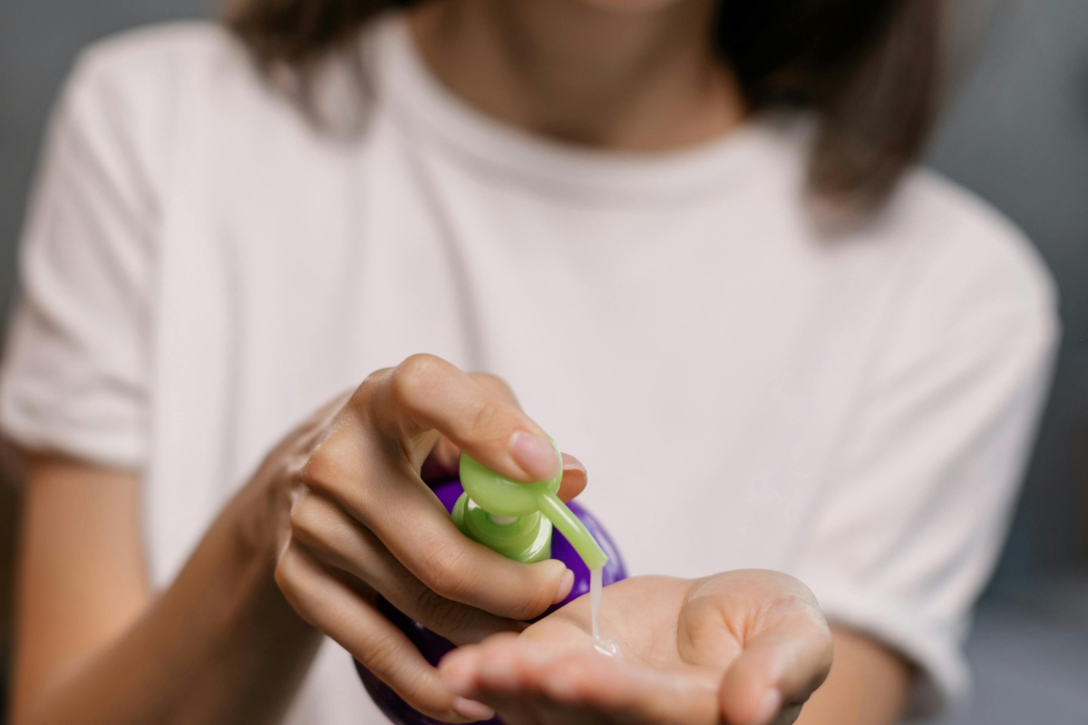 A person pumping cream into hand