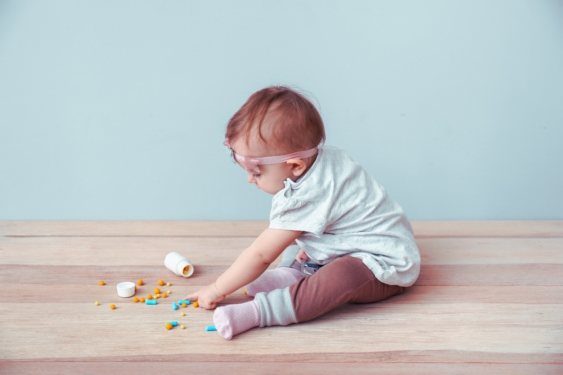 A child playing with a bottle of pills