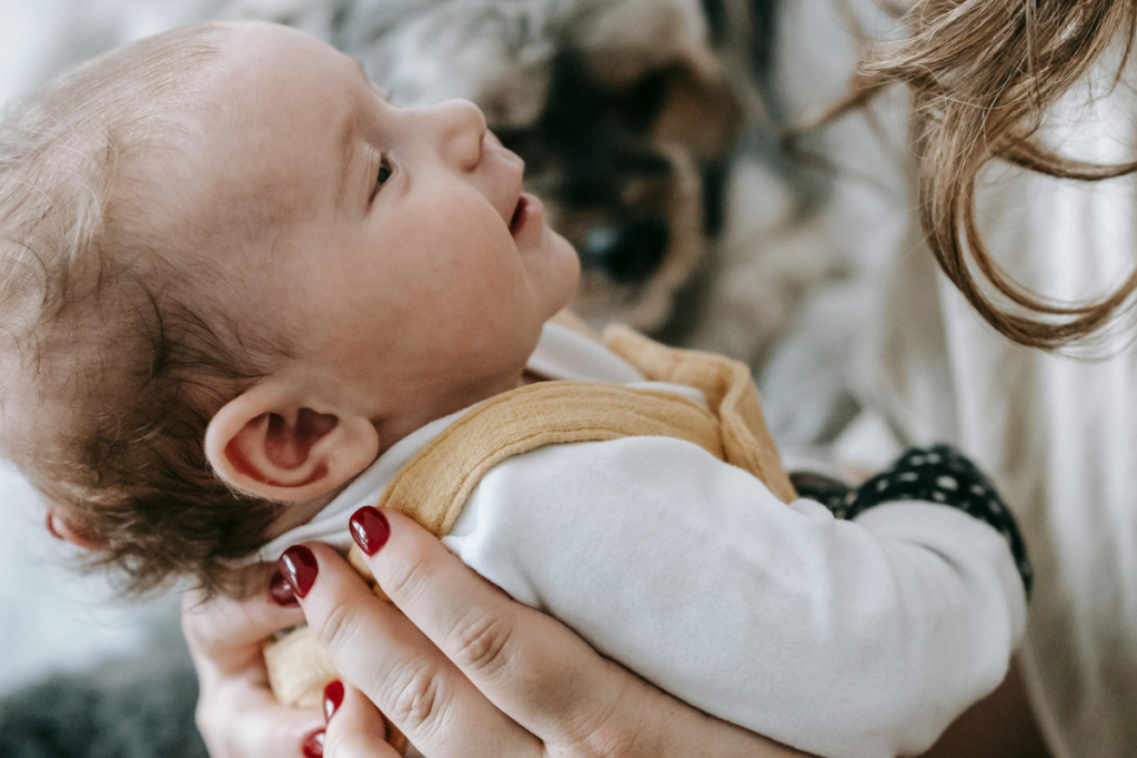 A parent's hands holding a baby
