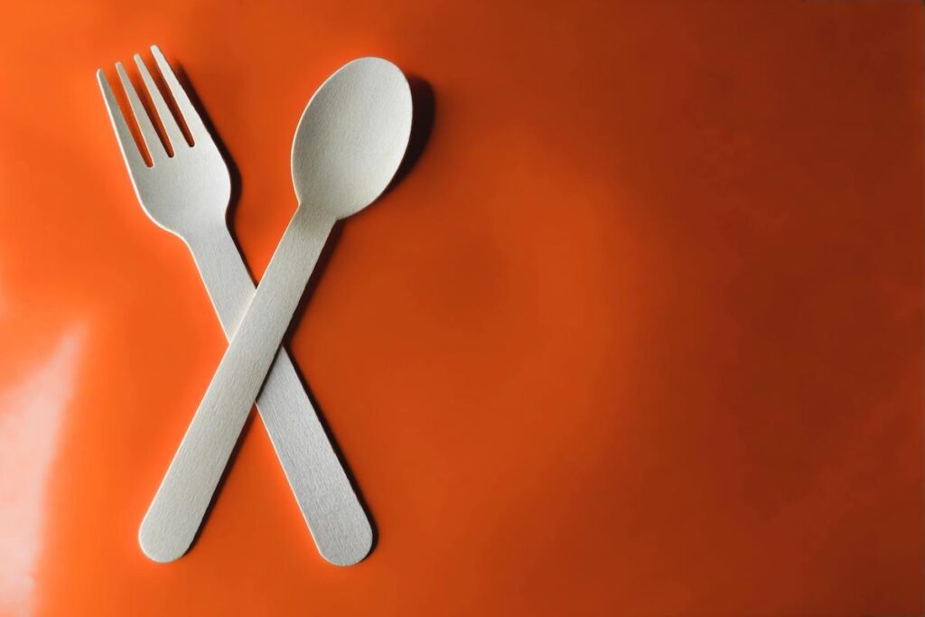 A wooden fork and a spoon in a red background