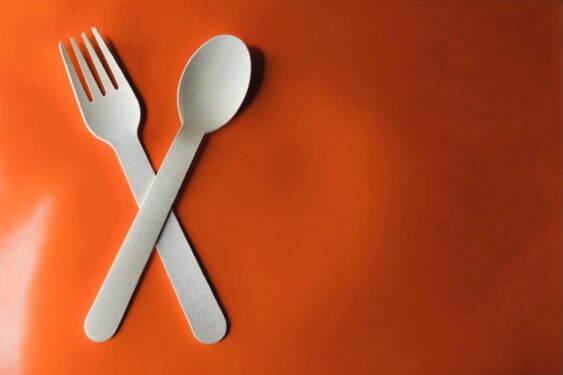 A wooden fork and a spoon in a red background