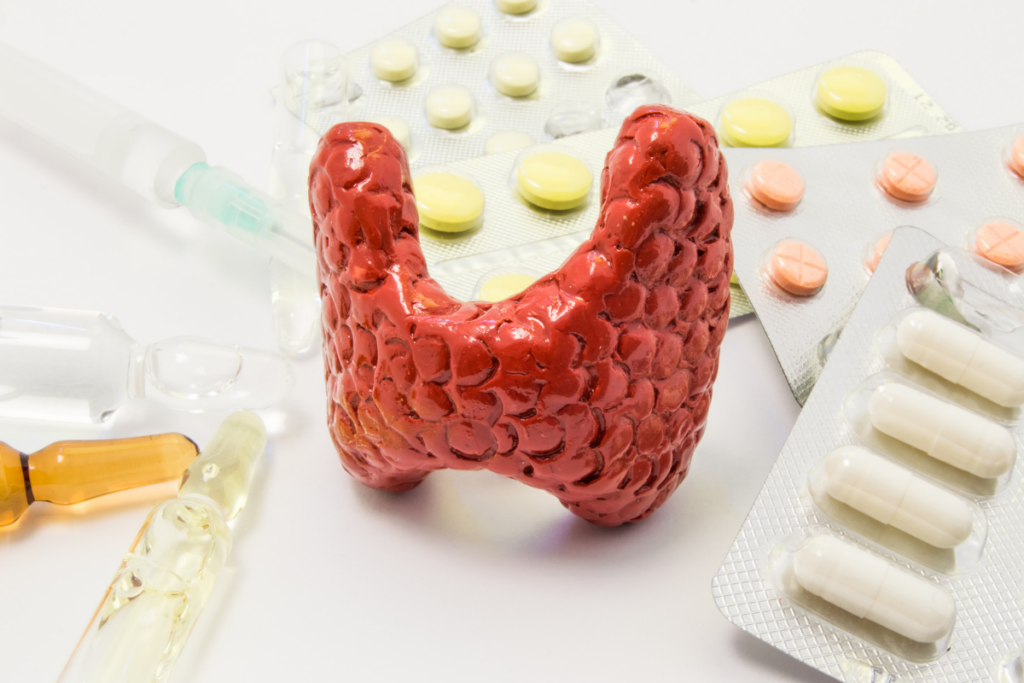 A model of thyroid gland with pills around it.