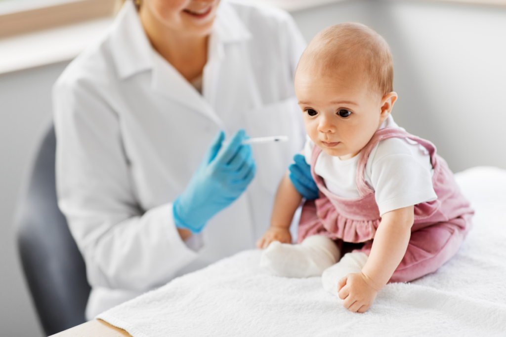 Baby being vaccinated by a doctor.