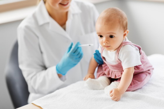 Baby being vaccinated by a doctor.