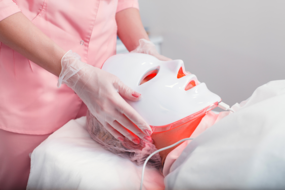 A person wearing red light mask in a professional set up.