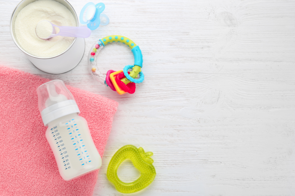 Formula , bottle, rattle and a pacifier on a table.
