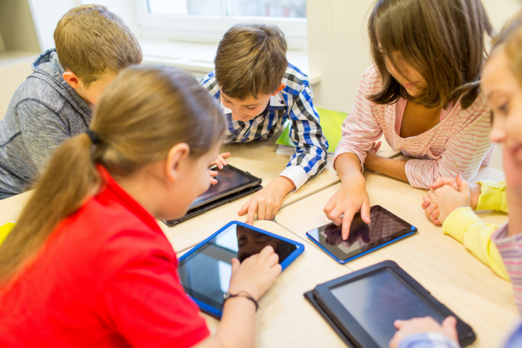 Kids in school looking at tabs.